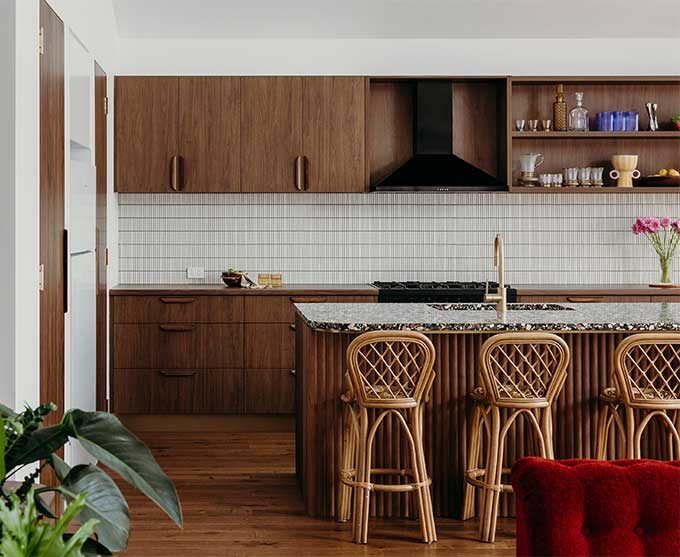 A Cozy Kitchen with Wooden Cabinets and A Bright Red Chair, Exuding Warmth — Construction in Newcastle